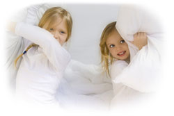 Kinder in kuscheligen Dissen und Decken